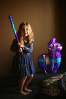 retrato de un cumpleaños niña con un murciélago planificación a descanso lama piñata foto