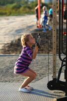 Five year old happy caucasian girl working out on the outdoor sports ground photo