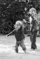 Children catching soap bubbles on summer playground photo