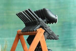 Row of paintball guns on a wooden rack photo