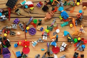 Kyiv, Ukraine - August, 5 2017 - Flat lay of Lego toys scattered on the wooden table photo