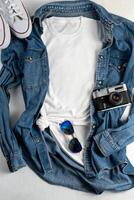 White T-shirt with place for text. Blue denim shirt, sneakers, glasses - a set of clothes for walking. T-shirt mockup for printing. Stylish kit photo