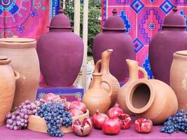 still life with pomegranate grapes and clay jugs of wine photo