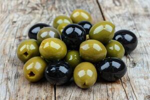 AI generated Set of green and black olives on wooden background. photo