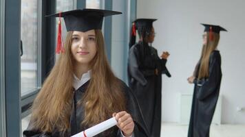 studenter av annorlunda nationaliteter i de universitet lobby. bemästra av social vetenskap. ett universitet examen i en mästare morgonrock med en diplom av högre utbildning är stående i främre av de kamera video