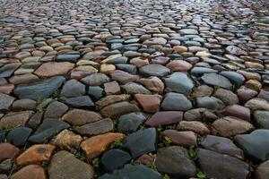 Wet multicolored cobblestone pavement in the city square on a rainy day. photo