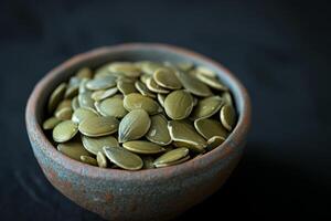 AI generated Pumpkin seeds in a small bowl on black background. photo