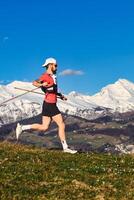 Sporty man practices nordic walking in the hills photo