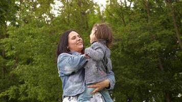 Lycklig ung mamma och liten dotter spelar och skrattande på internationell mors dag i sommar grön parkera utomhus- video