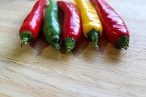 Top and perspective view of chili pepper and steel knife on a wooden cutting board with an isolated background photo