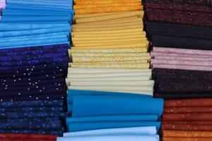 Detailed close up view on samples of cloth and fabrics in different colors found at a fabrics market photo