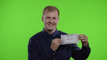 Joyful man showing Black Friday inscription note, smiling looking satisfied with low prices video