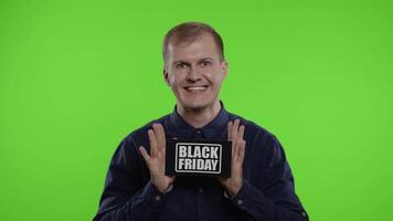 Excited man showing Black Friday inscription note, smiling looking satisfied with low prices video