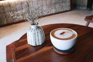 hot coffee, cappuccino coffee or latte coffee or flat white or mocha coffee and caspia flower in a vase photo