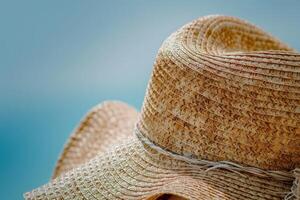 AI generated A stylishly designed straw hat stands out against a vivid blue background, showcasing intricate details and elegant craftsmanship. photo