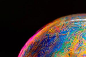 AI generated Close-up of a soap bubble showing vibrant colors and abstract patterns, reflecting light on a black background. photo