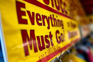 AI generated A vibrant yellow sign with bold red letters announcing that everything must go, signaling a clearance sale. photo