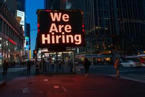 AI generated A vibrant sign on a bustling city street boldly proclaims We Are Hiring, inviting passersby to seize new opportunities. photo