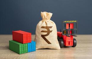 Forklift with shipping containers and indian rupee money bag. GDP and production. Import or export. Trade, economics and transport industry. Tariffs and tax collections. Production of containers. photo