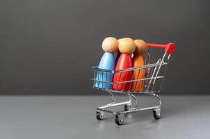 People in a shopping cart. Marketing, consumerism. Human trafficking. Products and marketing strategies. Buyer preferences. Customers photo