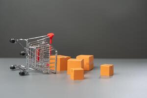 An overturned shopping cart with boxes of goods falling out. Fall in demand for goods. Decrease in purchasing power of buyers. Market research, marketing. photo