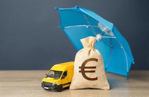 Delivery van and euro money bag under an umbrella. Cargo and parcel insurance. Warranty obligations. Logistics security. photo