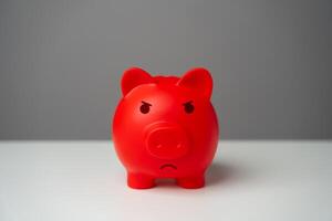 Angry red inflated piggy bank. Overheated financial market. Difficult economic conditions. Threat to savings. Heavy burden on the budget, high expenses and the likelihood of bankruptcy. photo