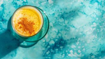 AI generated Turmeric latte on bright azure background with copy space. photo