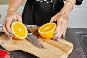 Hand squeezing fresh orange juice on white background for recipes and healthy drinks. photo