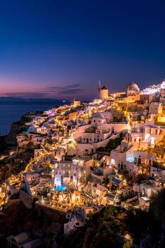 Perfect travel landscape. Santorini at night, long exposure photograph after sunset, Mediterranean sea, Greece. Amazing beauty cozy and romantic night view of famous vacation destination, night lights photo
