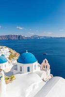 ciudad de oia en la isla de santorini, grecia. casas tradicionales blancas y azules famosas con flores bajo un clima soleado sobre la caldera, mar Egeo. hermoso paisaje de verano, vista al mar, vacaciones de viaje de lujo foto