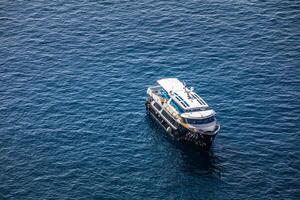 Drone view of a sailing yacht and speed boat at sea. Luxury yacht sailing in mediterranean sea bay. Arial landscape, cliffs and deep sea view. Summer recreational outdoor activity, copy space photo