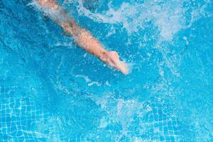 niño salpicaduras en el frio agua de un piscina en verano foto