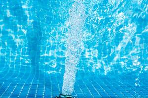 Child splashing in the cool water of a pool in summer photo