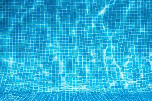 Child splashing in the cool water of a pool in summer photo