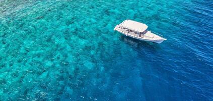 increíble vista aérea, costa de isla tropical con coral y playa en maldivas. increíble arrecife de coral y hermosa vista aérea del mar azul y aguas poco profundas. concepto de vacaciones de verano, viajes exóticos foto