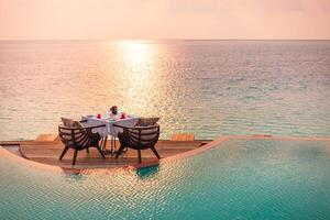 marina ver debajo puesta de sol ligero con comida mesa con infinito piscina alrededor. romántico tranquilo Aléjate para dos, Pareja concepto. sillas, comida y romance. lujo destino comida, Luna de miel modelo foto