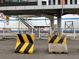 The yellow and black road signs at the port show the direction of the ship's bridge as well as the check-in gate photo