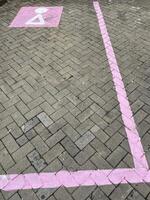 Paving block parking with unique pink parking lines and symbol in rest areas photo