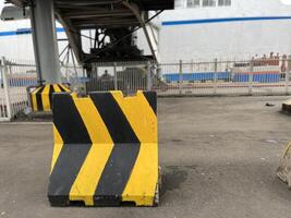 The yellow and black road signs at the port show the direction of the ship's bridge as well as the check-in gate photo