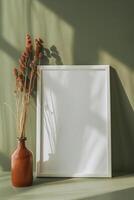 AI generated empty white canvas frame mockup with dried plants in vase on green wall photo