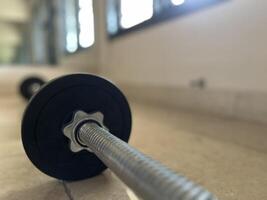 Gym equipment such as dumbbells, barbells, sit up benches and workouts photo