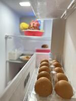 Fresco frutas y huevos en el refrigerador foto
