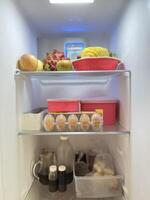 Fresh fruits and eggs in the refrigerator photo