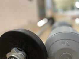 Gym equipment such as dumbbells, barbells, sit up benches and workouts photo