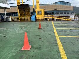 Road symbol cone in rest area parking lot and ship with yellow guide lines for cars photo