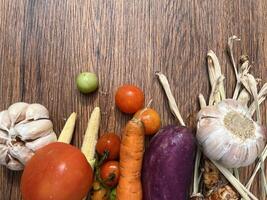 Vegetables tomatoes carrots and other on wooden table close up photographed from above photo