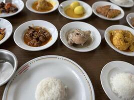 Indonesian food, authentic Padang cuisine, fried chicken, rendang, with white rice photo