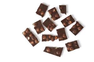 Small pieces of chocolate with nuts on a white background. top view photo