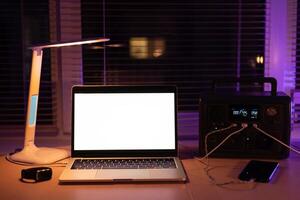 Charging station for laptop and desk lamp when there is no light during blackout. Generator power bank battery in the absence of electricity. at home table photo